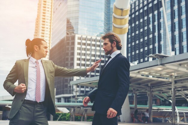 Two businessmen mad each other  trying to come to an agreement.