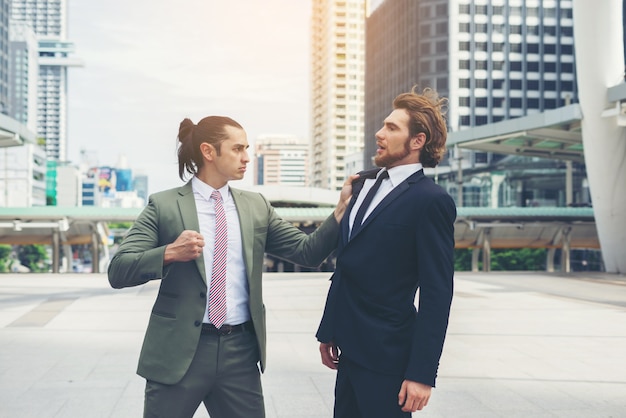 Two businessmen mad each other  trying to come to an agreement.