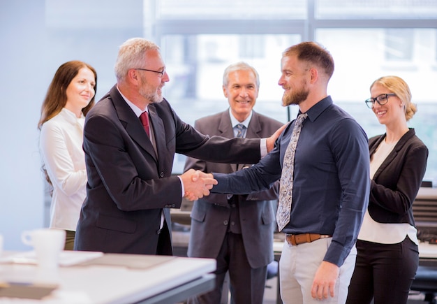 Two businessmen shaking hands congratulating on promotion