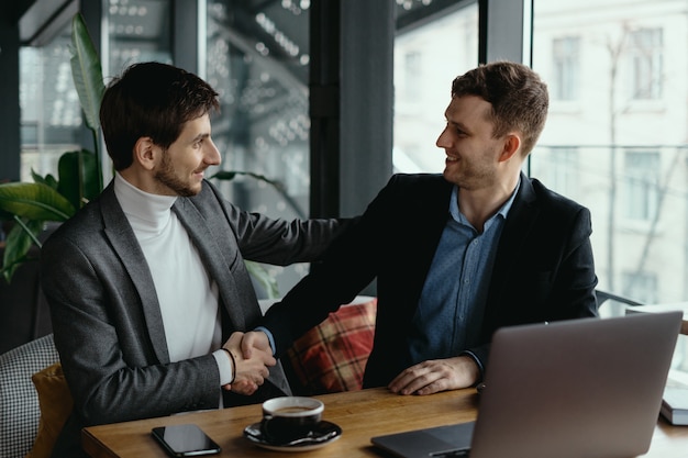 Two businessmen shaking hands while meeting in lobby