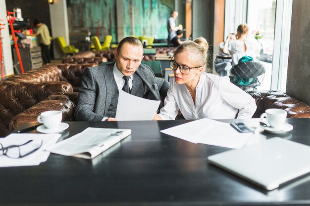 Two businesspeople analyzing document in caf�