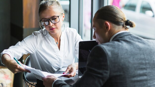 Two businesspeople checking agreement in restaurant