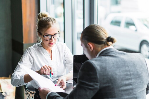 Two businesspeople doing paperwork in caf�