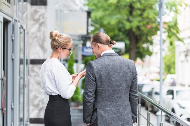 Two businesspeople looking at smartphone