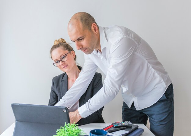 Two businesspeople using laptop in office