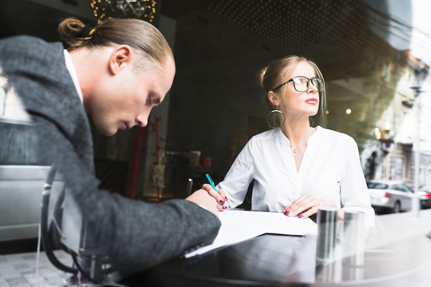 Two businesspeople working on document in restaurant