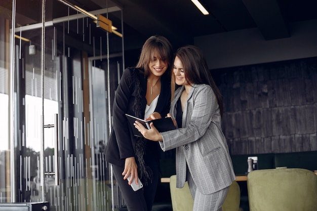 Free photo two businesswomen working in a cafe