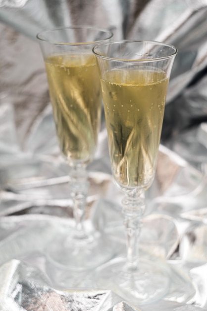 Two champagne glasses on blurred silver background