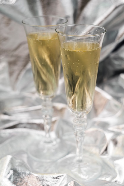 Два бокала для шампанского на размытом серебряном фоне