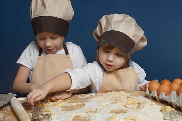 Two charming kids baking pastry together in kitchen