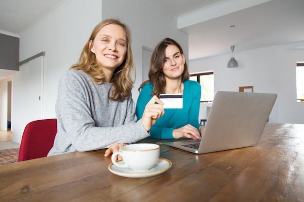 Due clienti femminili allegri che pagano online