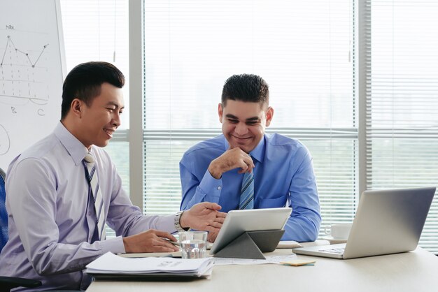 Two cheerful managers generating ideas at the brainstorming session