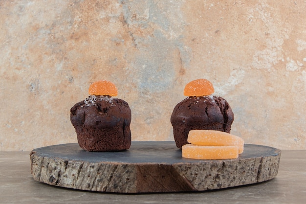 Two chocolate brownies with marmalades on wooden piece