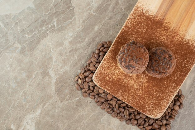 コーヒー豆と木の板に2つのチョコレートクッキー