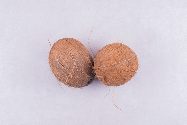 白い表面に分離された2つのココナッツ。
