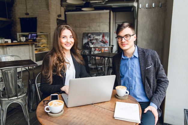 Two colleagues discuss something near laptop