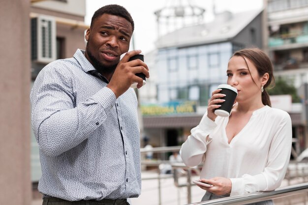 パンデミック中に職場で一緒にコーヒーを飲んでいる2人の同僚