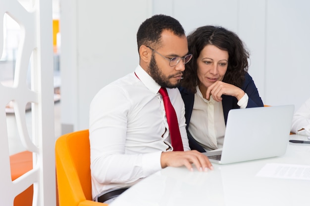 Two colleagues looking at laptop screen together