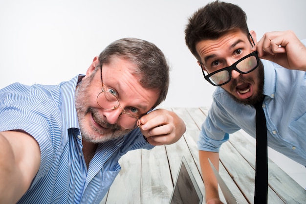 Two colleagues  taking the picture to them self sitting in  office