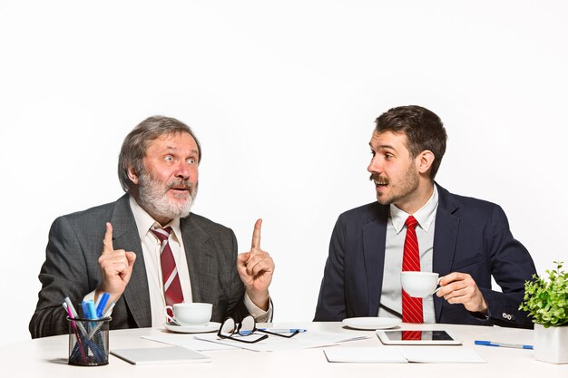 The two colleagues working together at office on white background. They actively and emotionally discussing current plans