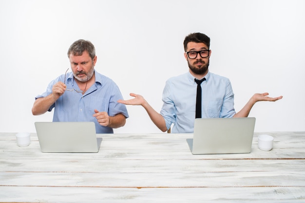 The two colleagues working together at office on white background