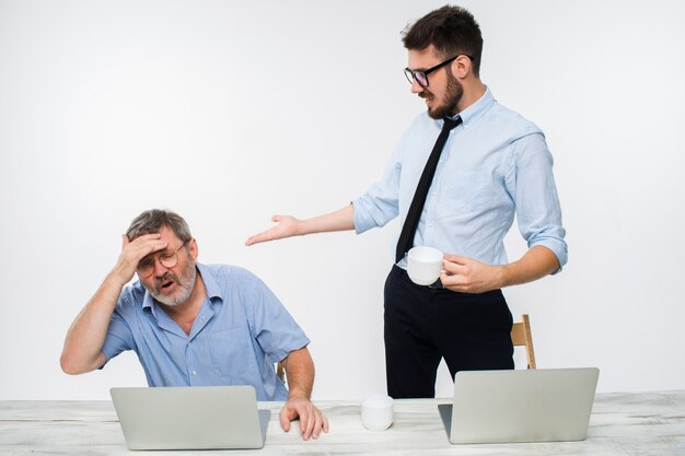 The two colleagues working together at office on white background