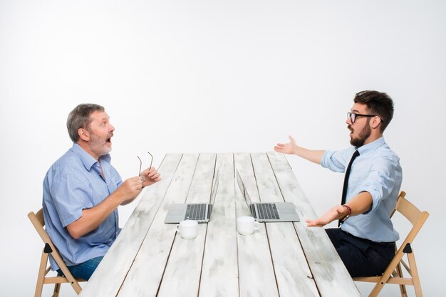 The two colleagues working together at office on white background