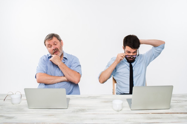 The two colleagues working together at office on white background