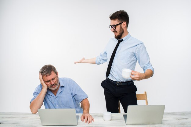 The two colleagues working together at office on white background