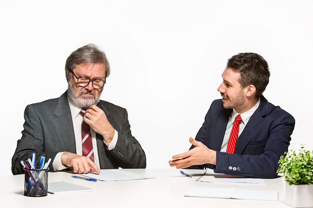 I due colleghi che lavorano insieme in ufficio su studio bianco