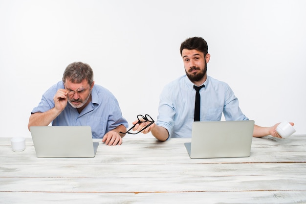 two colleagues working together at office on white