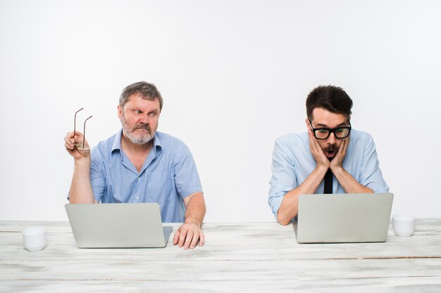 two colleagues working together at office on white