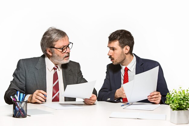 The two colleagues working together at office on white.