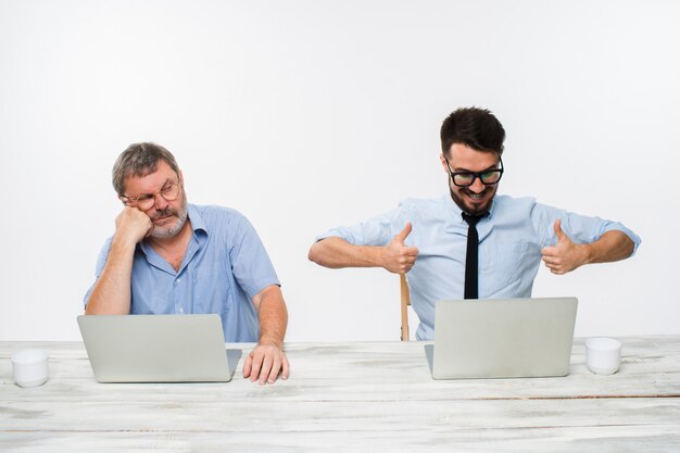 two colleagues working together at office on white