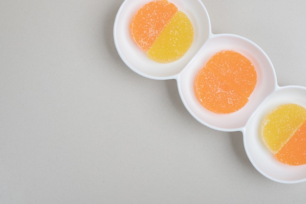 Бесплатное фото Две цветные желейные конфеты на белой тарелке