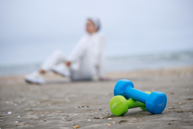 Two colorful dumbbells on sand High quality photo