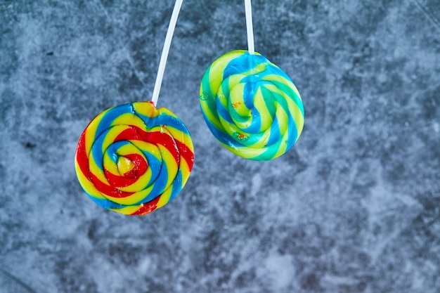 Free photo two colorful lollipops on marble background.