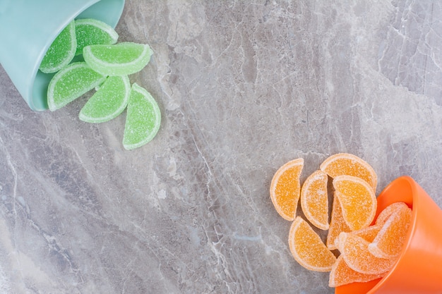 Due piatti colorati pieni di marmellate di zucchero su sfondo marmo.