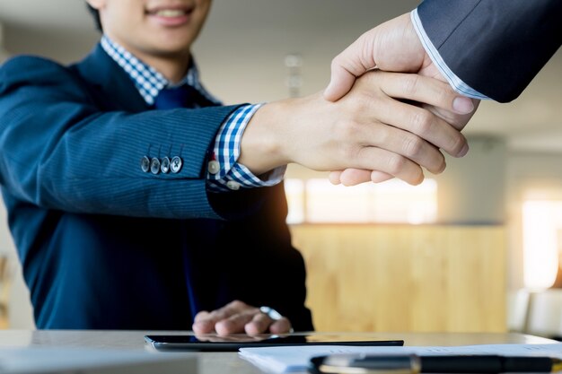 Two confident business man shaking hands during a meeting in the office, success, dealing, greeting and partner concept