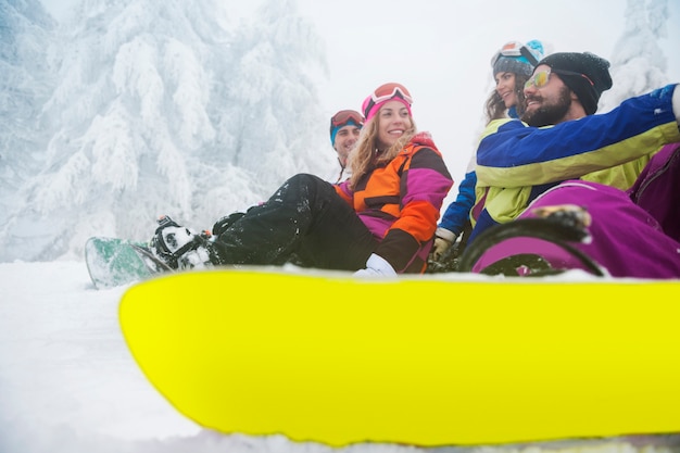 Two couples having fun and snowboarding