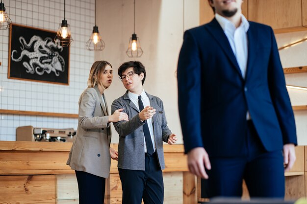 Two coworkers Staring and Gossiping About Their Male Colleague at the office