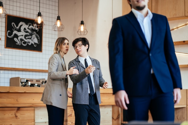 Two coworkers Staring and Gossiping About Their Male Colleague at the office