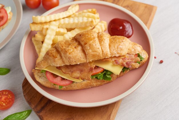 Two croissant sandwiches on wooden table, top view,