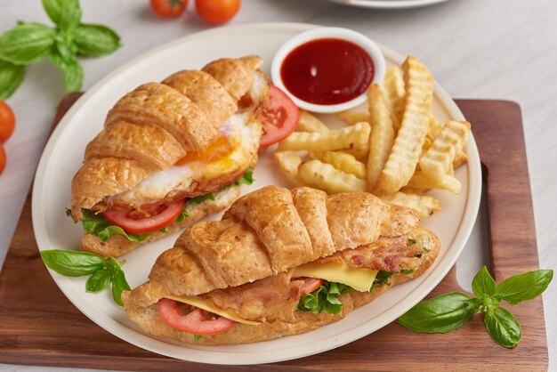 Two croissant sandwiches on wooden table, top view