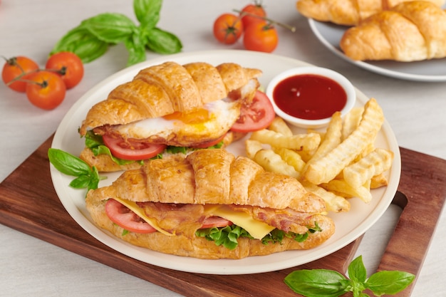 Two croissant sandwiches on wooden table, top view