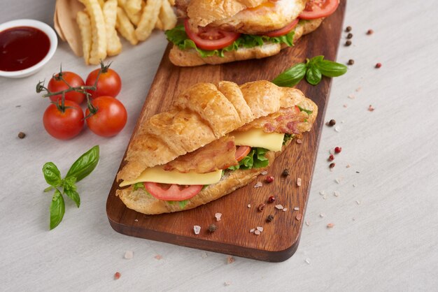 Two croissant sandwiches on wooden table