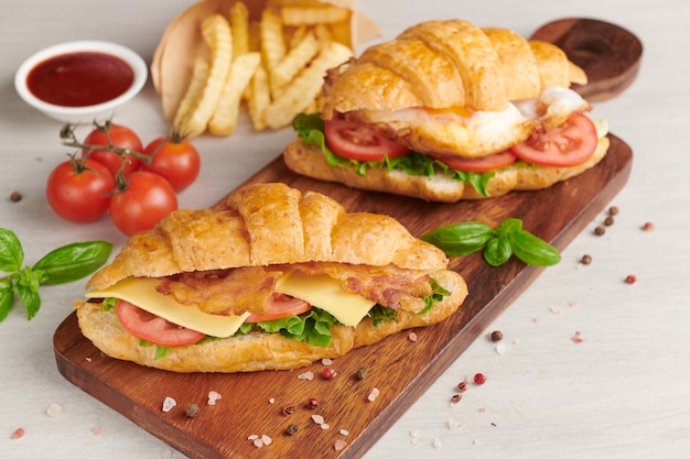 Two croissant sandwiches on wooden table