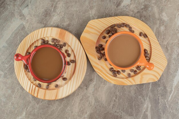 Two cups of coffee and coffee beans on wooden plates