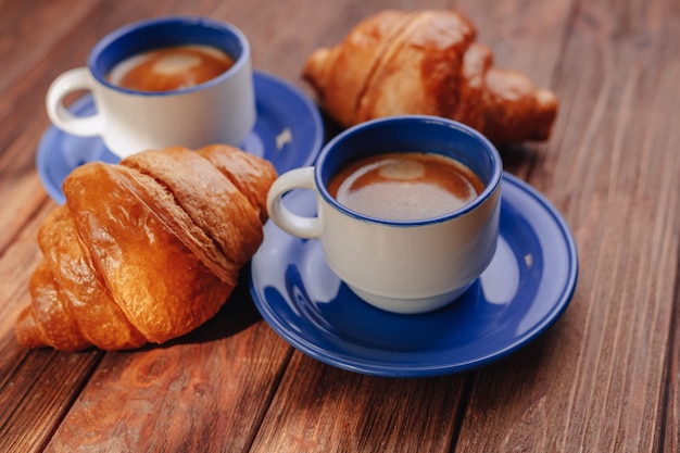 Two cups of coffee and croissants 