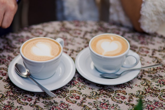 Free photo two cups of coffee with milk stand on the table